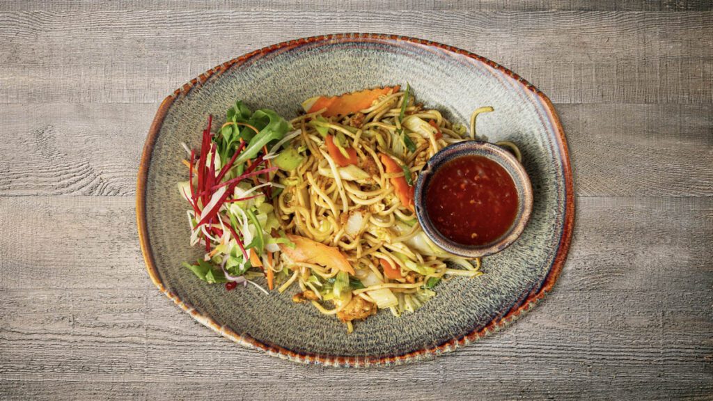 gebratene Eiernudeln mit Möhren, Chinakohl, Porree, Sojasprossen und Röstzwiebeln, wahlweise mit Tofu, Hühnerfleisch, Rindfleisch, Garnelen, Ente Kross, Vegane Ente, Paniertes Hühnerfleisch